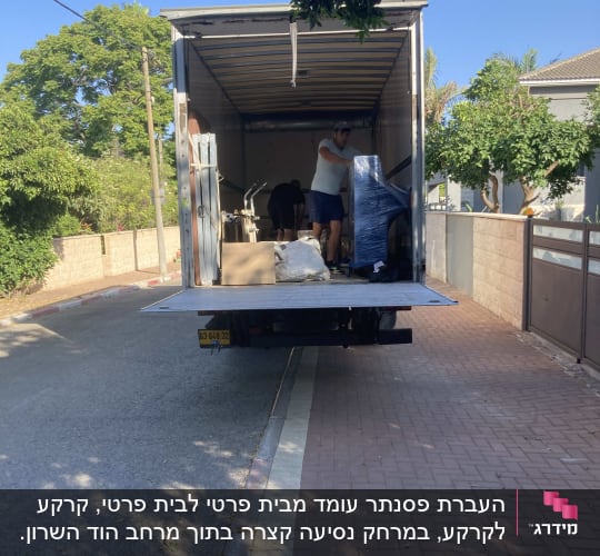 אדם מעמיס חפצים למשאית הובלה פתוחה